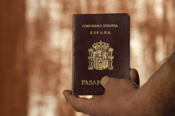 hand of man holding a passport in the foreground