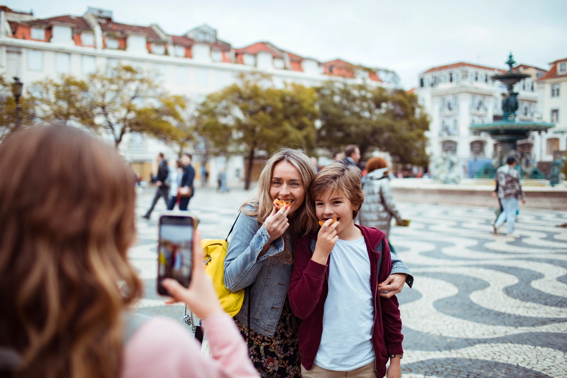 Young Caucasian family trying the local cuisine and taking a picture in Pra?a de D. Pedro IV square in Lisbon Portugal