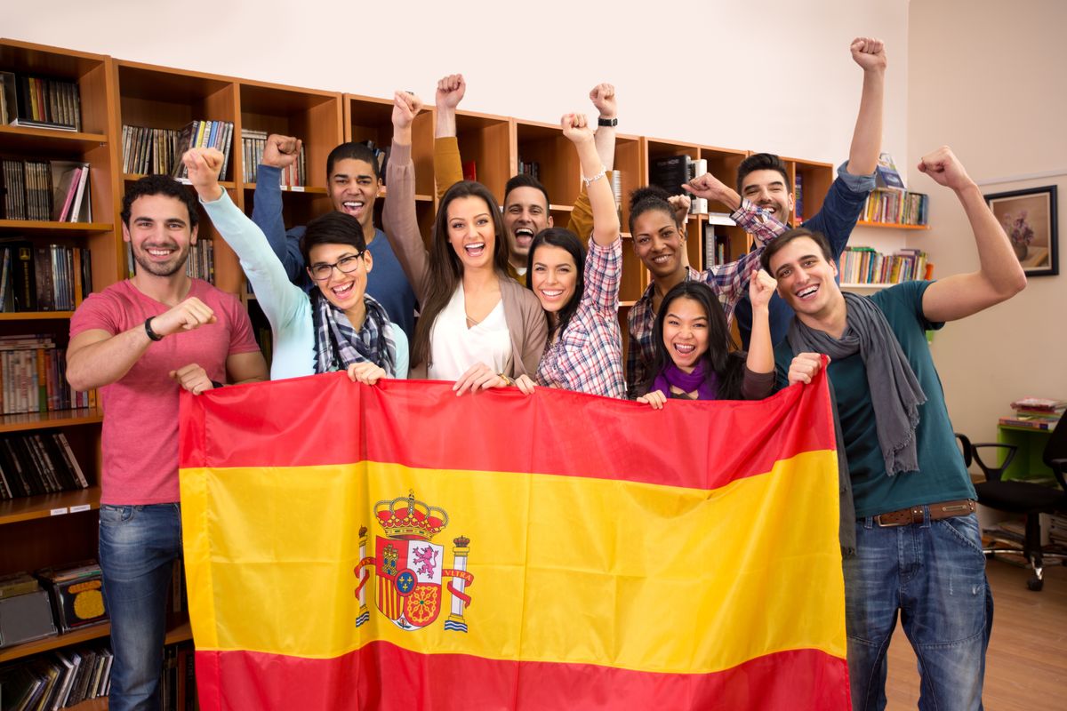 Team of excited Spanish students with victory smile and raised fists